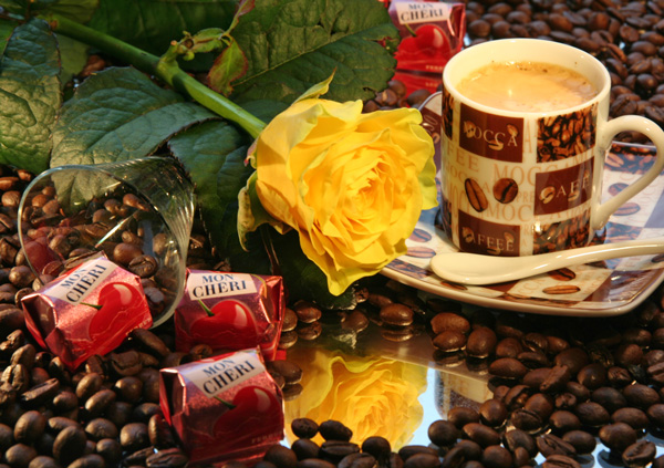 Espresso auf Kaffeebohnen, gelbe Rose und Mon Cheri